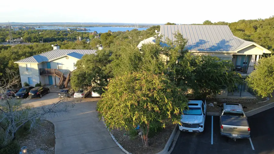 Aerial of Baycliff apartment buildings, resident parking and Lake LBJ in the distance