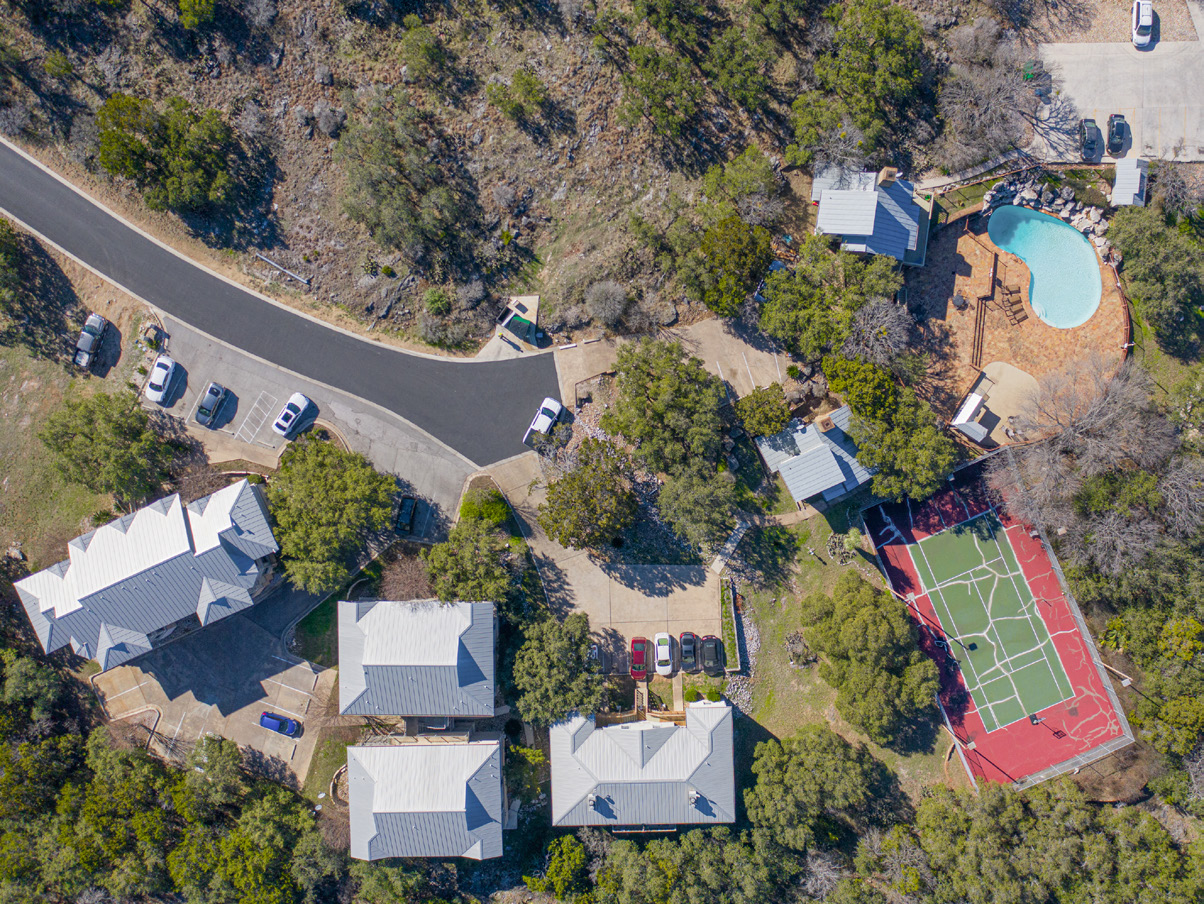 Top-down aerial of full Baycliff property showing pool, tennis court, and all buildings