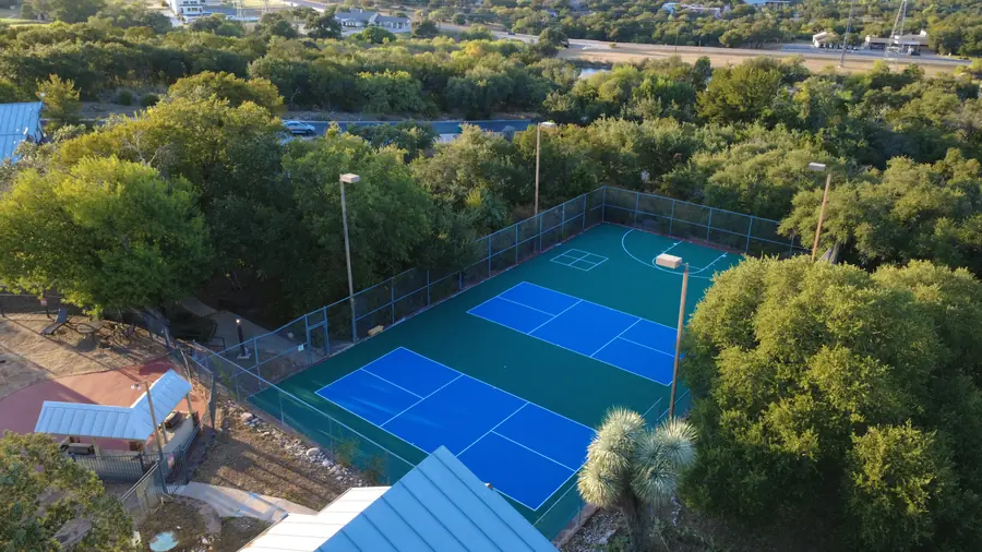 Wide aerial of Baycliff Apartments pickleball and basketball court complex in Horseshoe Bay TX