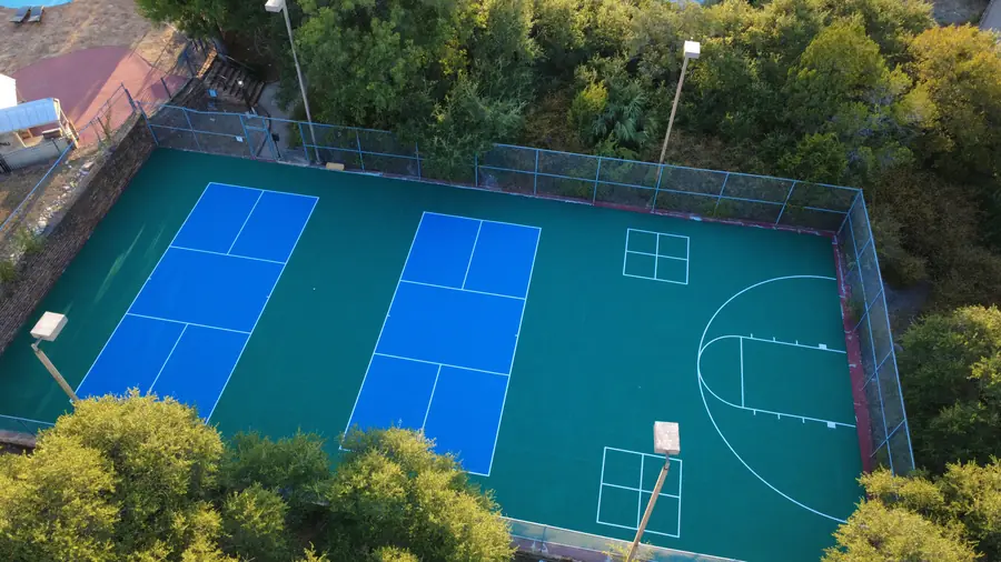 Top-down aerial of two pickleball courts and basketball court at Baycliff Apartments, Horseshoe Bay TX