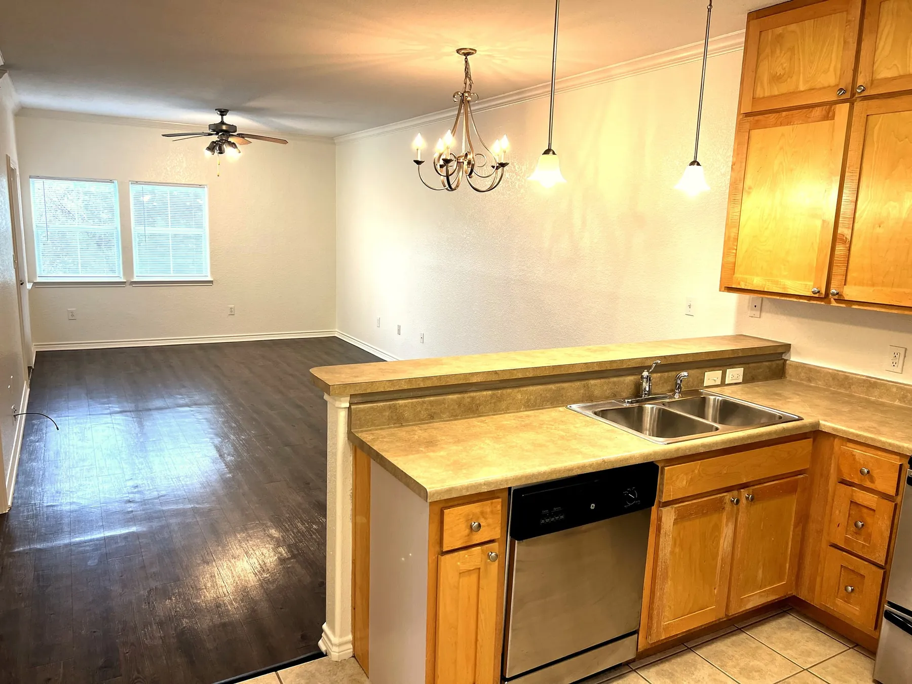The Pecan – open kitchen and living room with chandelier, Baycliff Apartments
